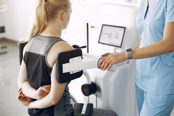 A healthcare professional assists a patient with a rehabilitation exercise machine.